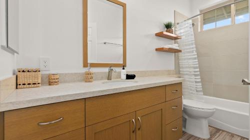a bathroom with a sink and a toilet and a mirror at Mauna View by AvantStay 10min to Beach Backyard in Waianae