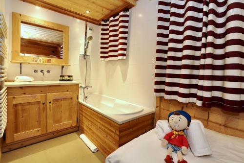 a toy doll sitting on a bed in a bathroom at Charming village chalet in Saint-Bon-Tarentaise