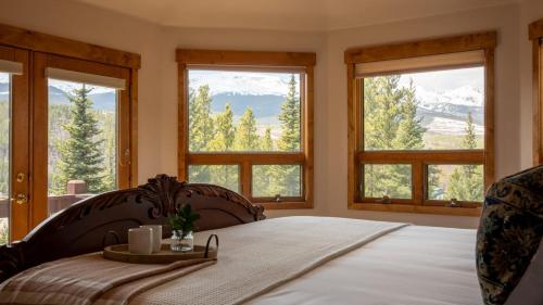 1 dormitorio con 1 cama y ventanas con vistas a las montañas en Zendo by AvantStay Serene Mountain Abode w Hot Tub Views, en Breckenridge