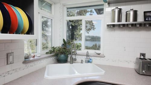 a kitchen with a sink and a window at Fairway Harbor View by AvantStay Outdoor Oasis in Freeland