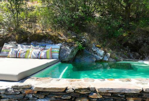 a pool of water with a bed in the middle at Historic Chestnut Kiln With Pool In The Cévennes in Les Plantiers