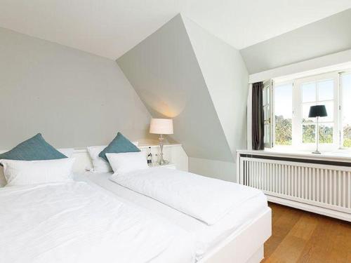 una camera da letto bianca con un letto grande e una finestra di Prahl-Hues-2 a Kampen