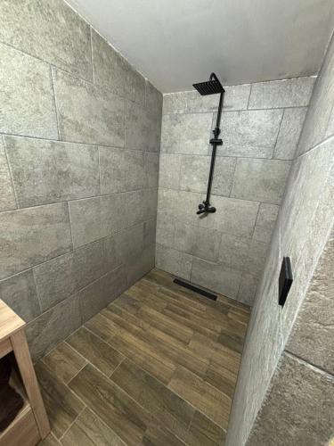 a bathroom with a shower with a stone wall at Cabañas La Esperanza in Creel