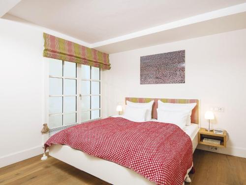 una camera da letto con un letto rosso e bianco e una finestra di Kuckucksnest a Kampen