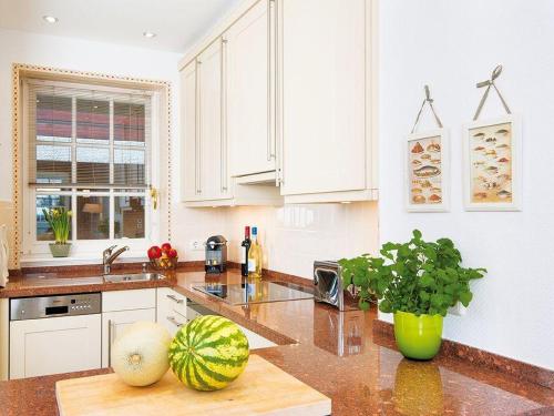 a kitchen with white cabinets and a melon on a counter at Kampen-Kliff-3 in Kampen