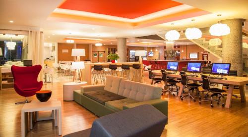 a living room with a couch and a table and chairs at Fiesta Inn Queretaro Centro Sur in Querétaro