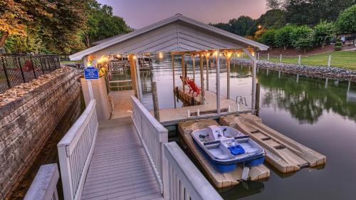 a house with a boat on a dock in the water at Sip Sip Away by AvantStay Pool Hot Tub in Westport