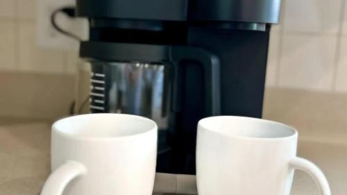 two white cups sitting next to a coffee maker at Sip Sip Away by AvantStay Pool Hot Tub in Westport