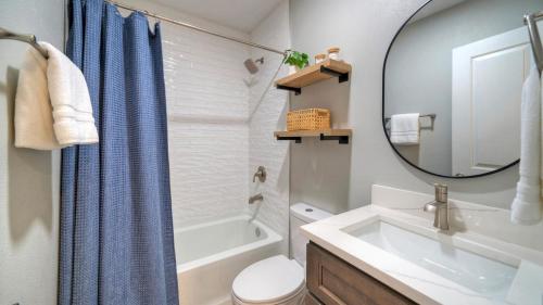 Un baño con lavabo, inodoro y espejo. en Port A Escape w Pools Patio Walk to Beach La Concha by AvantStay, en Port Aransas
