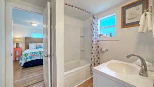 a bathroom with a tub and a sink and a bed at Rock the Boat by AvantStay 5 Blocks to Beach in Port Aransas