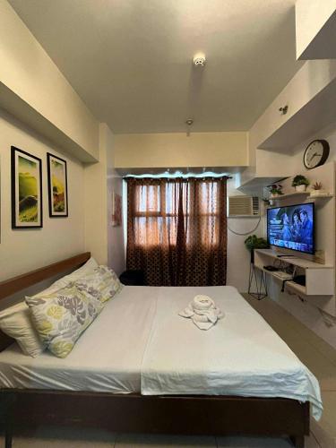 a bedroom with a large bed and a television at Nica's Place in Cebu City