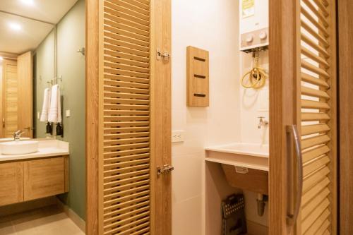 a bathroom with a wooden door and a sink at Minimalist 1BR Amazing View in Morros Eos in Cartagena de Indias