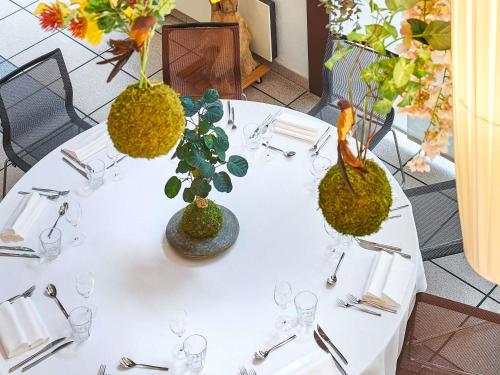 a white table with glasses and plants on it at Novotel Paris Rueil Malmaison in Rueil-Malmaison