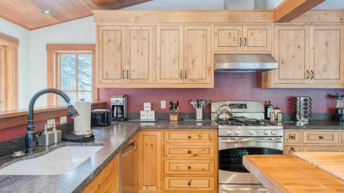 a kitchen with wooden cabinets and a sink at Ward Creek by AvantStay 5 Min Walk to Lake Deck in Tahoe City