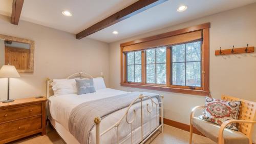 a bedroom with a bed and a window and a chair at Ward Creek by AvantStay 5 Min Walk to Lake Deck in Tahoe City