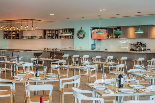 a restaurant with wooden tables and white chairs at Fiesta Inn Puerto Vallarta Isla in Puerto Vallarta