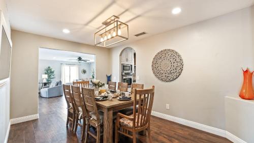 a dining room and living room with a table and chairs at Breathtaking Meadows by AvantStay Temecula Group Retreat Pool Pickleball Firepit Hot Tub in Temecula
