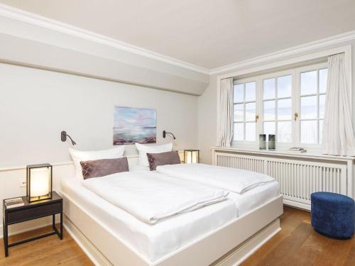 a white bedroom with a large bed and a window at Hansenhoog-4 in Kampen