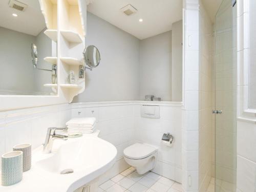 a white bathroom with a toilet and a sink at Hansenhoog-4 in Kampen