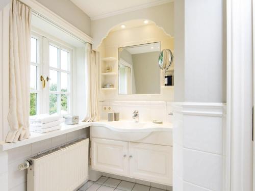 a white bathroom with a sink and a mirror at Hansenhoog-3 in Kampen
