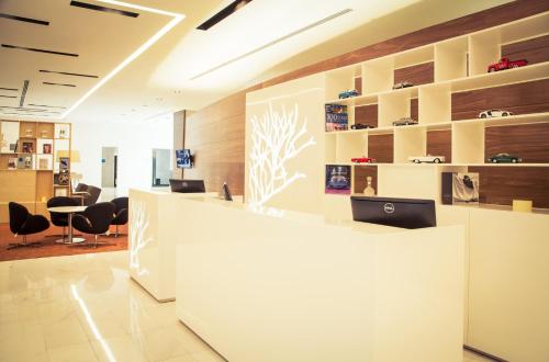 an office lobby with a reception counter and chairs at Fiesta Inn Plaza Central Aeropuerto in Mexico City