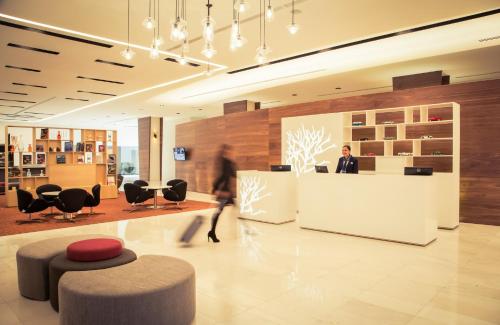 a man standing at a counter in a lobby at Fiesta Inn Plaza Central Aeropuerto in Mexico City