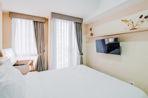 a bedroom with a white bed and a window at Tokyo Riverside Apartment @ PIK 2 in Tangerang