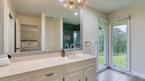 Jefferson CityにあるAmber Escape by AvantStay 3 Unique Spaces Poolの洗面台と大きな鏡のあるバスルーム