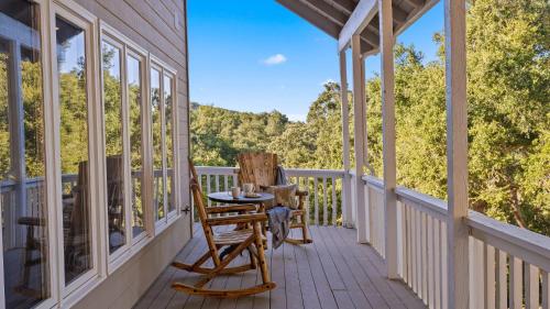 a porch with two chairs and a table on it at Hidden Oaks Farmhouse by AvantStay Hot Tub Deck in Atascadero