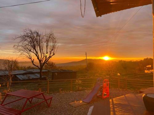 a woman laying on a porch watching the sunset at Muddy-Tales I Your cob home in Bīr