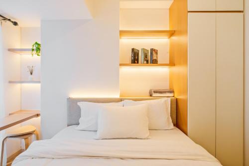 a bedroom with a bed with white pillows at Tokyo Riverside Apartment @ PIK 2 in Tangerang