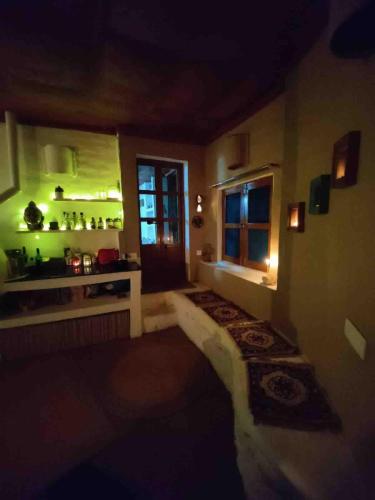 a dark room with a kitchen and a window at Muddy-Tales I Your cob home in Bīr
