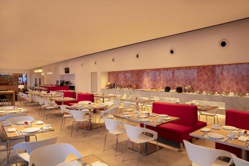 a restaurant with tables and chairs and a bar at Fiesta Inn Parque Puebla in Puebla