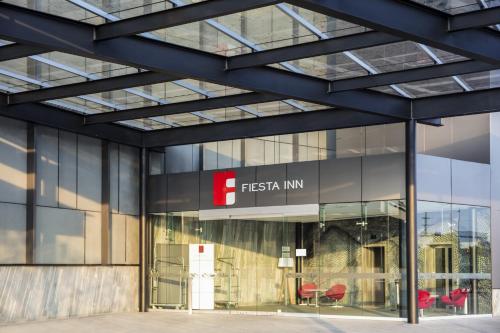 a glass facade of a building with the fsis firm sign at Fiesta Inn Parque Puebla in Puebla