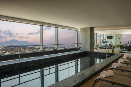 a hotel swimming pool with a view of the city at Fiesta Inn Parque Puebla in Puebla
