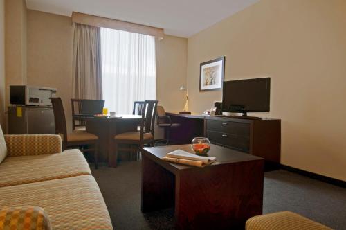 a hotel room with a couch and a tv at Fiesta Inn Express Perinorte in Mexico City