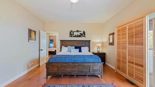 ein Schlafzimmer mit einem großen Bett mit einem hölzernen Kopfteil in der Unterkunft Hot Tub Fire Pit Game Room Amazing Deck Views Sky Canyon Lodge by AvantStay in Blue Jay