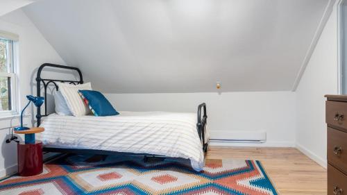 a bedroom with a bed and a rug at Charcoal Chalet by AvantStay A Design w Firepit in New Paltz