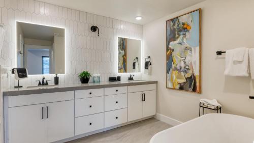 a bathroom with two sinks and a large mirror at Ski La Vie by AvantStay Hot Tub Game Room Near the Ski Slopes in Heber City