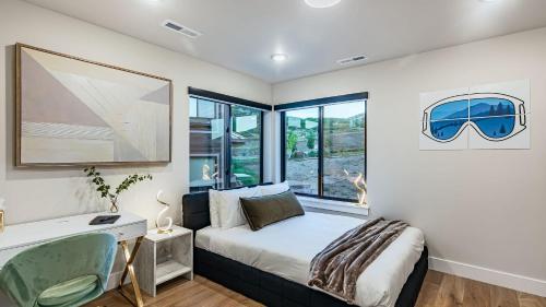 a bedroom with a bed and a desk and window at Ski La Vie by AvantStay Hot Tub Game Room Near the Ski Slopes in Heber City