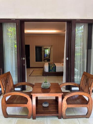 a room with two chairs and a table and a bed at Gita Maha Ubud Hotel by Mahaputra-CHSE Certified in Ubud