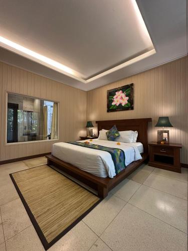 a bedroom with a large bed and a window at Gita Maha Ubud Hotel by Mahaputra-CHSE Certified in Ubud