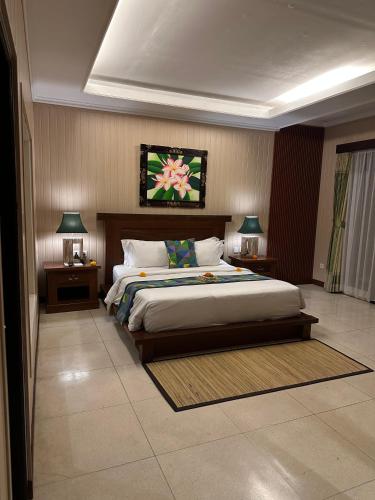a bedroom with a large bed with two nightstands and two lamps at Gita Maha Ubud Hotel by Mahaputra-CHSE Certified in Ubud