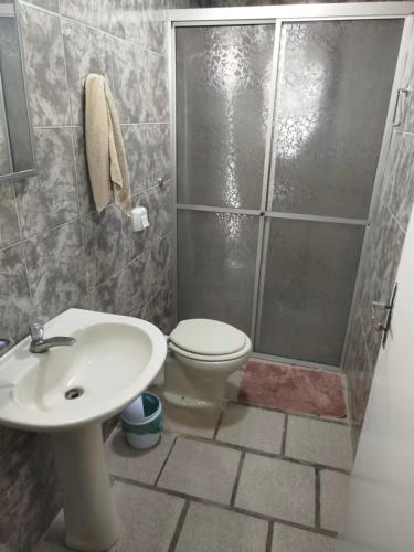 a bathroom with a shower and a toilet and a sink at Casa com piscina proximo da praia in Itapoa