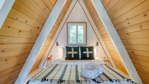 a bed in a room with a pointed ceiling at 2 Decks w Lake Glimpse Views Modern Luxe Cabin A-Frame Retreat by AvantStay in Lake Arrowhead