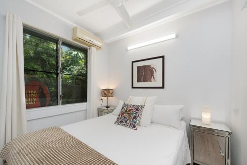 a white bedroom with a bed and a window at Island Holiday Memories in Nelly Bay in Nelly Bay
