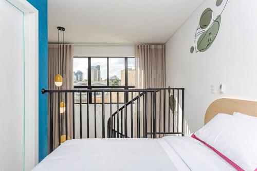 a bedroom with a bed and a balcony at Apartamento Duplex até 4 Pessoas com Vaga in Curitiba