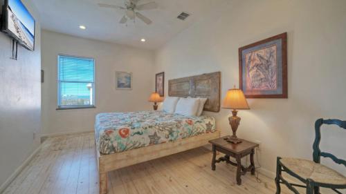 ein Schlafzimmer mit einem Bett, einem Stuhl und einem Ventilator in der Unterkunft Shared Pool w Bay Views Boat Dock Fishing Big Slough by AvantStay in Padre Island