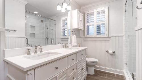 a white bathroom with a sink and a toilet at 302 Charleston by AvantStay Stunning Private Pool in Mount Pleasant