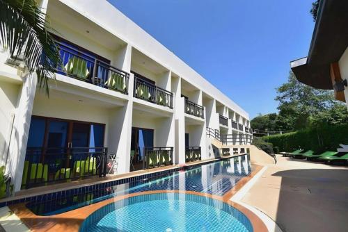 a hotel with a swimming pool in front of a building at The Green Hotel in Ko Lipe